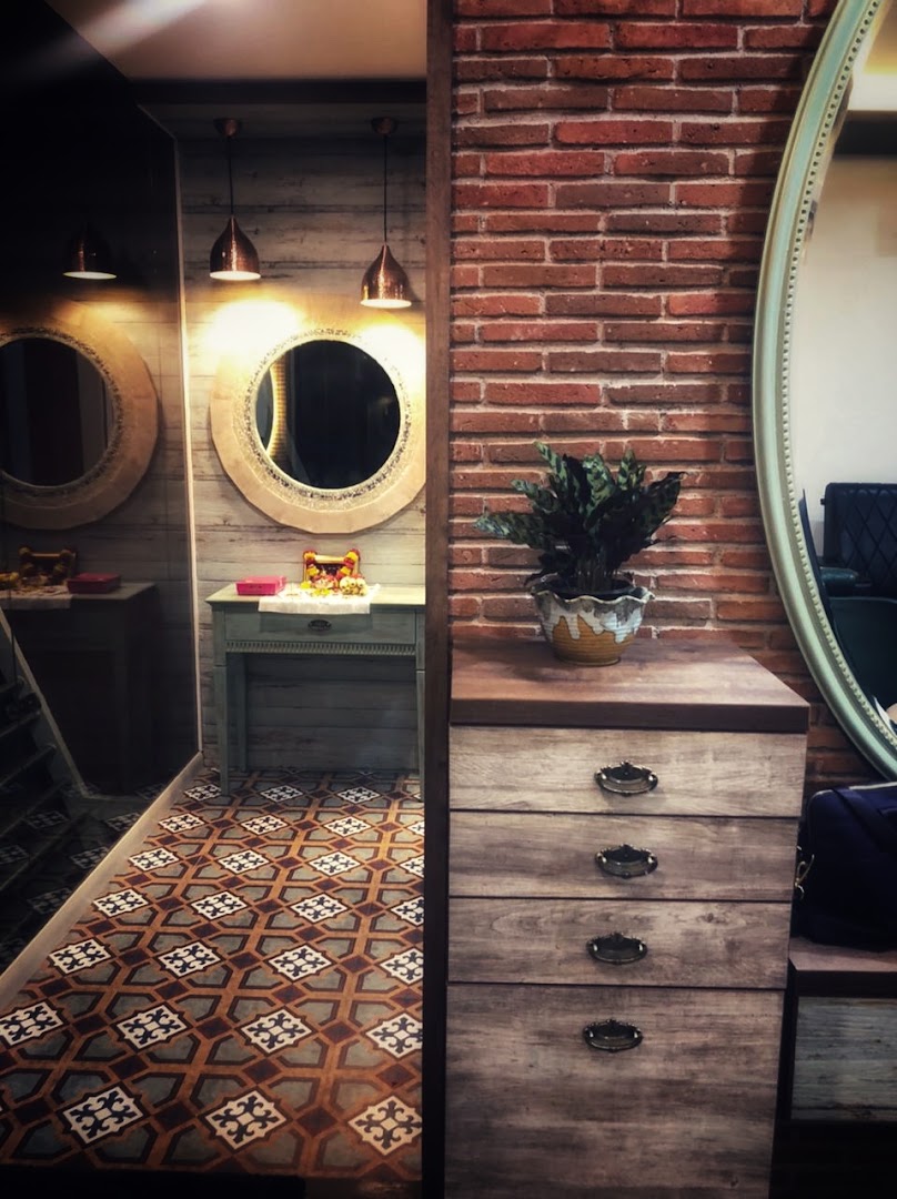 Round stone-framed mirrors and heritage-patterned floor tile in the pedicure corner
