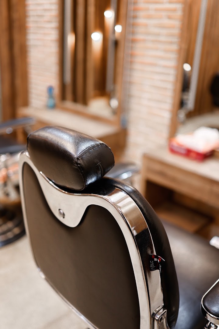 Detail of a black styling chair, brick and mirrors softened behind it
